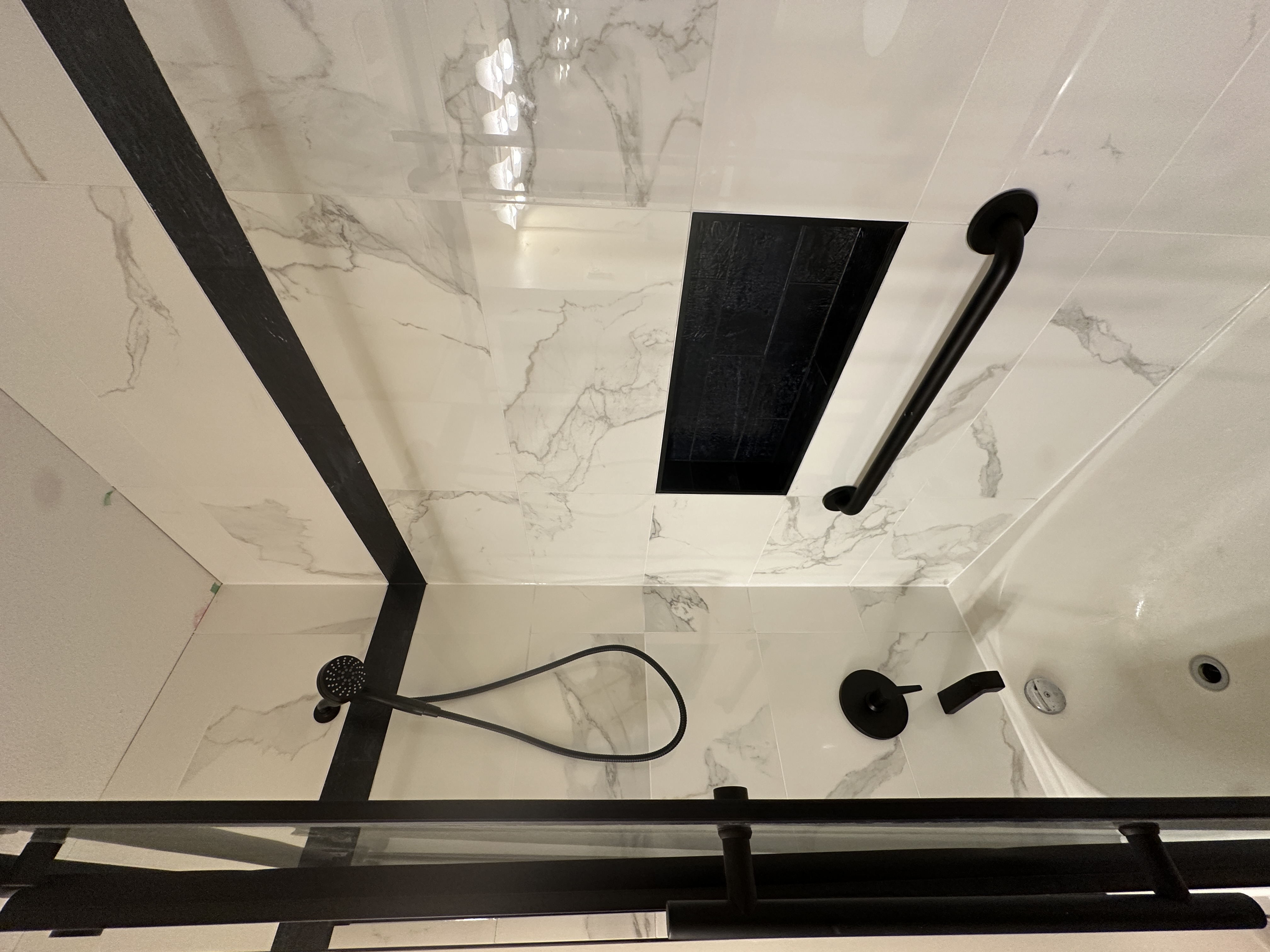 Recessed niche and matte black shower fixtures